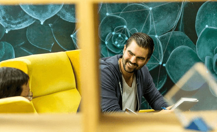 Two men working and laughing. Demonstrates two different leadership styles.